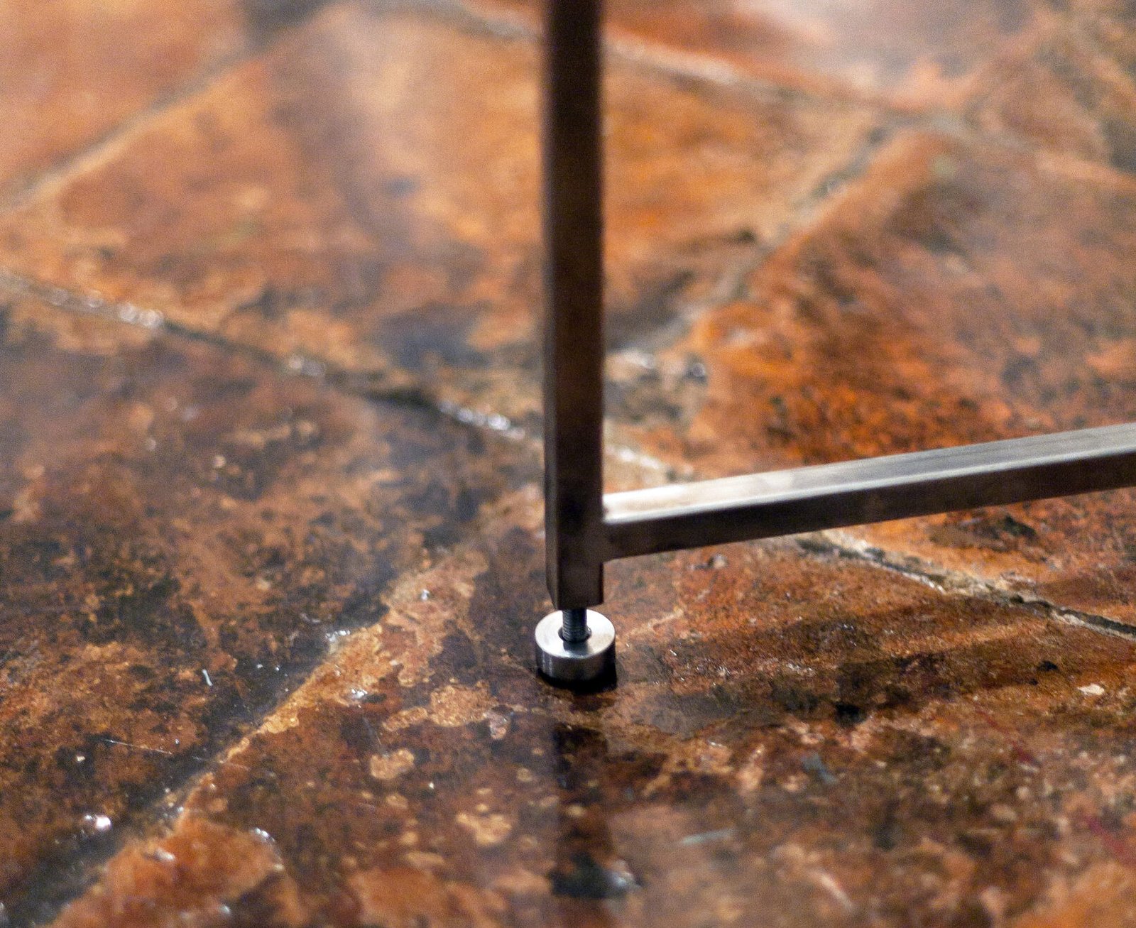 Limite - dettaglio del piedino regolabile che ne consente il livellamento su pavimenti irregolari